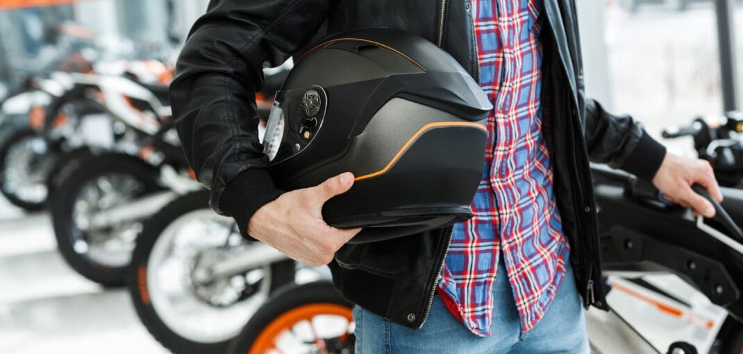 image of someone holding a motorcycle helmet in a shop - what to look for when buying a motorcycle helmet with Motohorse