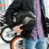 image of someone holding a motorcycle helmet in a shop - what to look for when buying a motorcycle helmet with Motohorse