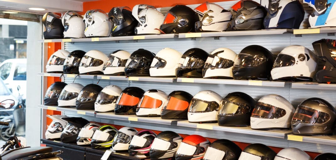 image of helmets for sale on motorcycle shop shelf - learn how much motorcycles cost with Motohorse, a motorcycle & powersports parts and accessories shop