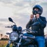 image of man on a motorcycle taking off helmet - motorcycle helmet size with motohorse, a motorcycle & powersports parts and accessories shop