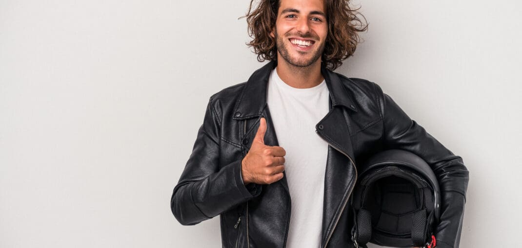 image of man holding a motorcycle helmet - learn how to deal with motorcycle helmet hair with Motohorse